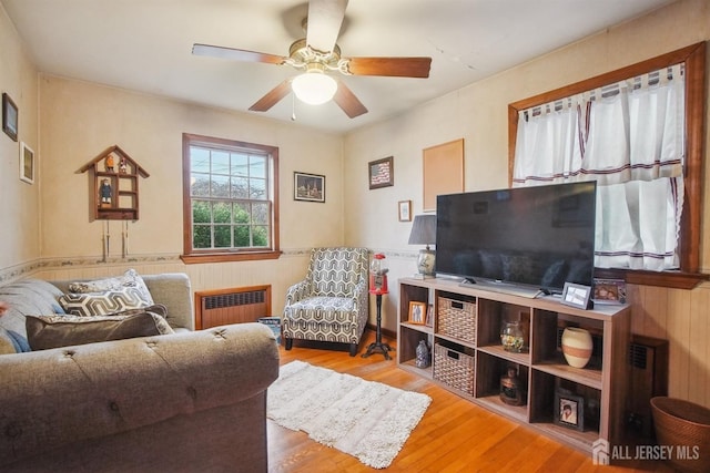 42 Frederick St, Carteret, NJ 07008 - living room with ceiling fan, wainscoting, wood finished floors, wooden walls, and radiator heating unit