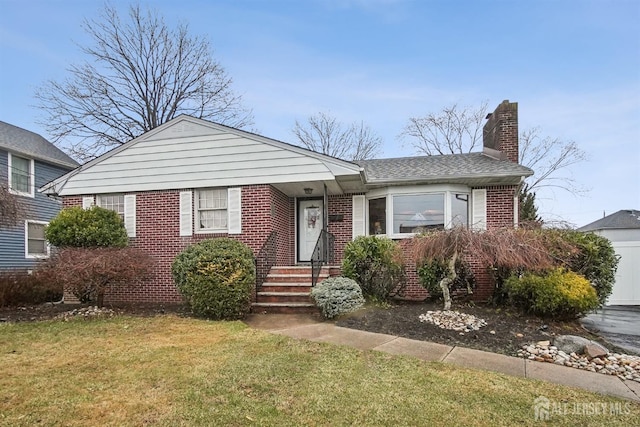 view of front of home featuring brick siding, a garage, a front yard, and a chimney
