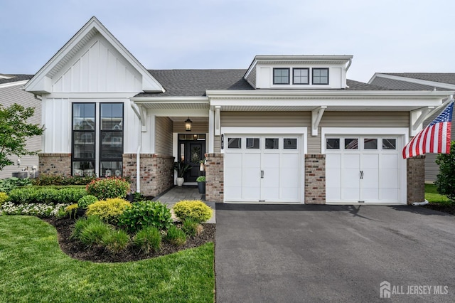 15 Woodspring Rd, Farmingdale, NJ 07727 - view of front of home featuring brick siding, driveway, an attached garage, board and batten siding, and a shingled roof
