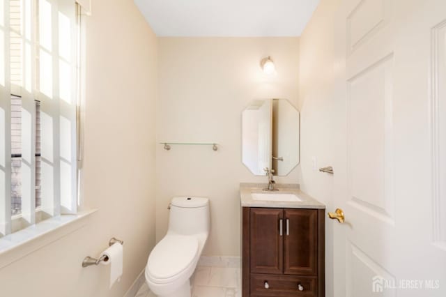 bathroom featuring a wealth of natural light, vanity, and toilet