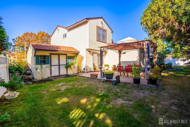 rear view of property featuring a gazebo, a yard, and a patio area