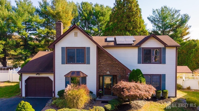 view of front of house with a garage and solar panels