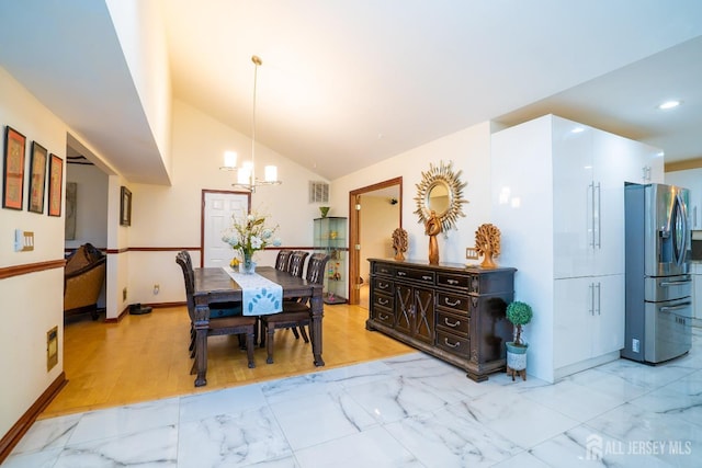 dining space with an inviting chandelier, light hardwood / wood-style flooring, and vaulted ceiling