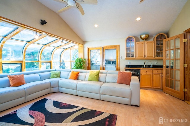 living room featuring light hardwood / wood-style floors, wine cooler, ceiling fan, and lofted ceiling