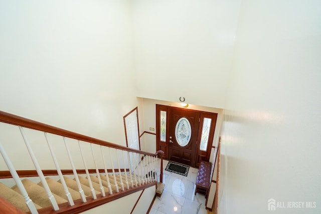 tiled foyer entrance with a towering ceiling