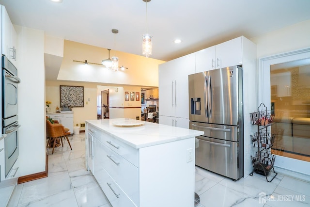 kitchen featuring white cabinets, a kitchen island, stainless steel appliances, and pendant lighting