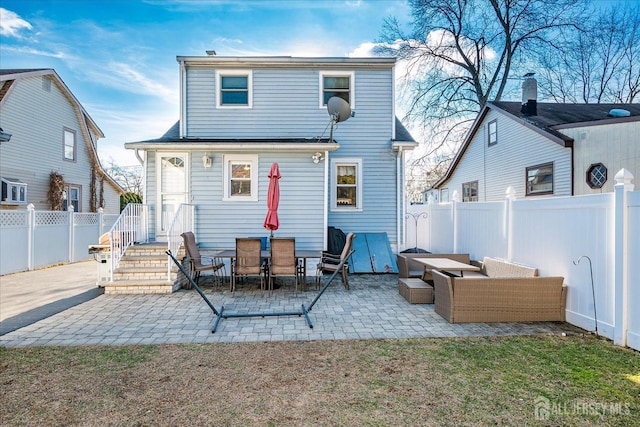 back of property with an outdoor living space and a patio