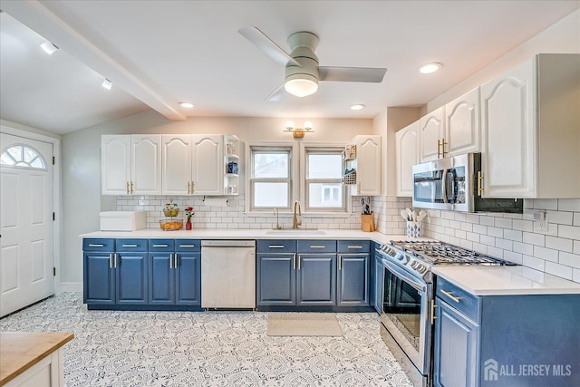 kitchen with sink, blue cabinets, white cabinetry, vaulted ceiling with beams, and appliances with stainless steel finishes