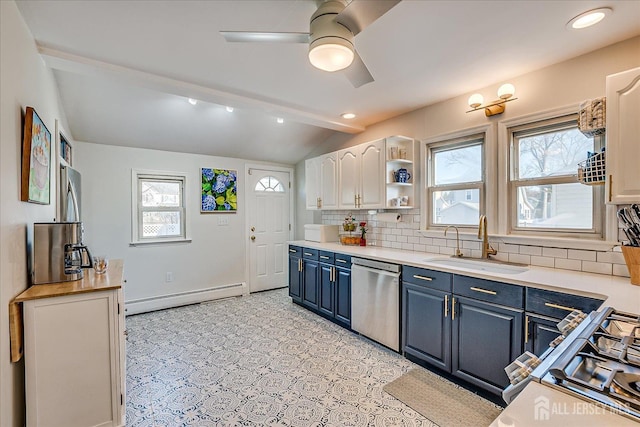 kitchen featuring baseboard heating, dishwasher, blue cabinetry, sink, and white cabinetry