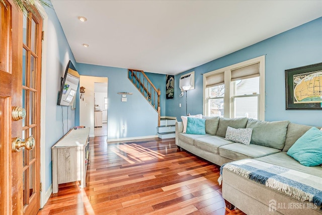 living room featuring a wall unit AC and hardwood / wood-style flooring