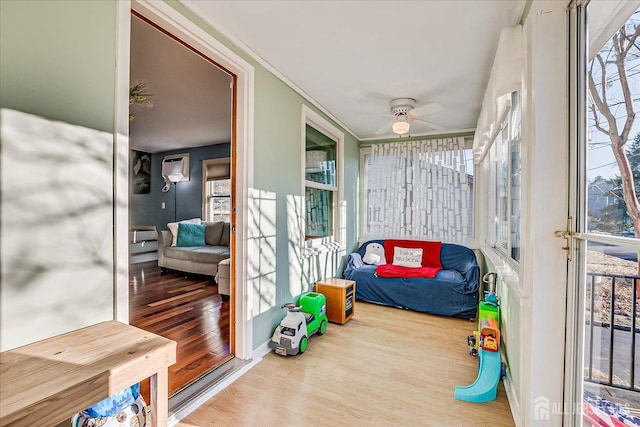 sunroom / solarium with ceiling fan and a wall mounted air conditioner