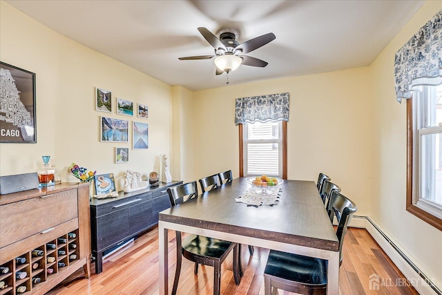 dining area featuring a baseboard heating unit, ceiling fan, and light hardwood / wood-style floors