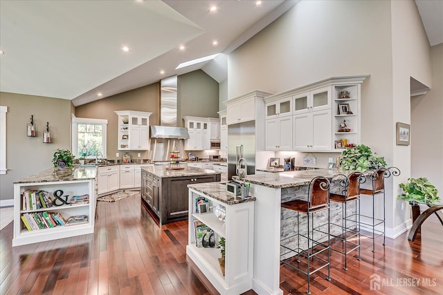 28 Evans Dr, Cranbury, NJ 08512 - kitchen featuring open shelves, wall chimney exhaust hood, high vaulted ceiling, a peninsula, and stainless steel built in refrigerator