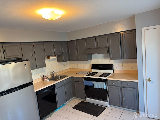 kitchen with stainless steel refrigerator, white gas range, black dishwasher, sink, and backsplash