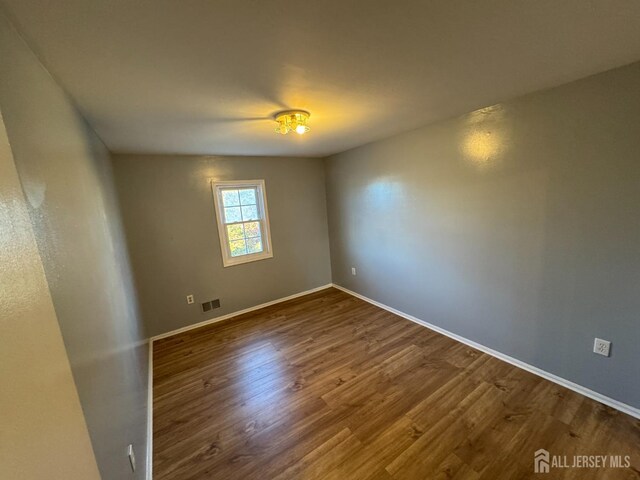 spare room with dark hardwood / wood-style flooring