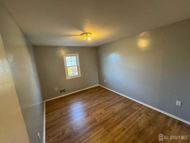 unfurnished room featuring dark wood-type flooring