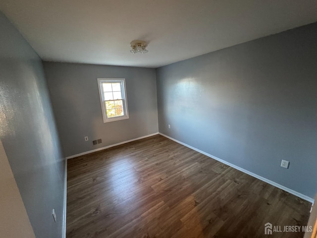 spare room with dark hardwood / wood-style floors