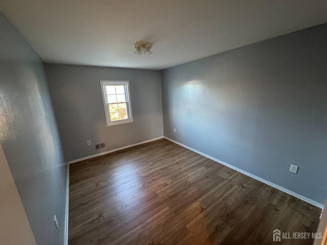 empty room featuring dark hardwood / wood-style flooring