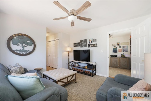 carpeted living area featuring baseboards and a ceiling fan