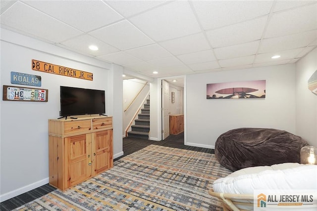 living area featuring stairs, recessed lighting, a paneled ceiling, and baseboards