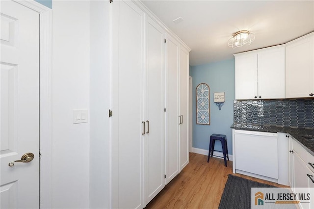 kitchen featuring backsplash, white cabinets, white dishwasher, light wood-type flooring, and baseboards