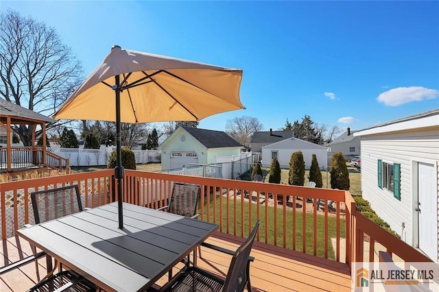 wooden deck with a fenced backyard, a residential view, outdoor dining area, and a lawn