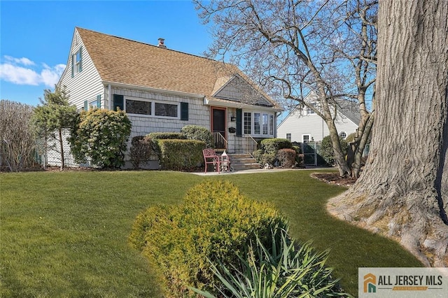 view of front of property with a front lawn, a chimney, and a shingled roof