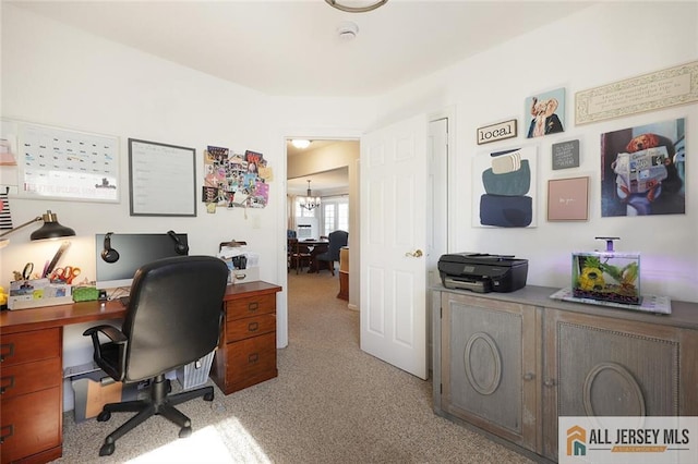 carpeted office space with a chandelier