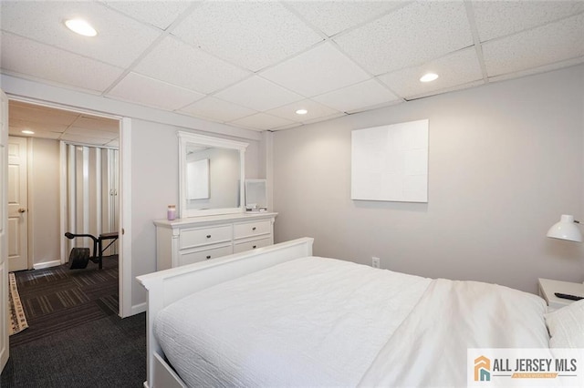 bedroom with dark colored carpet, a drop ceiling, and recessed lighting