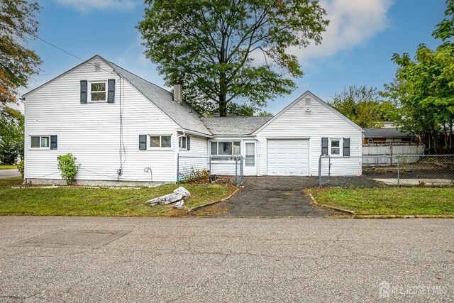 view of front of property with a garage and a front lawn