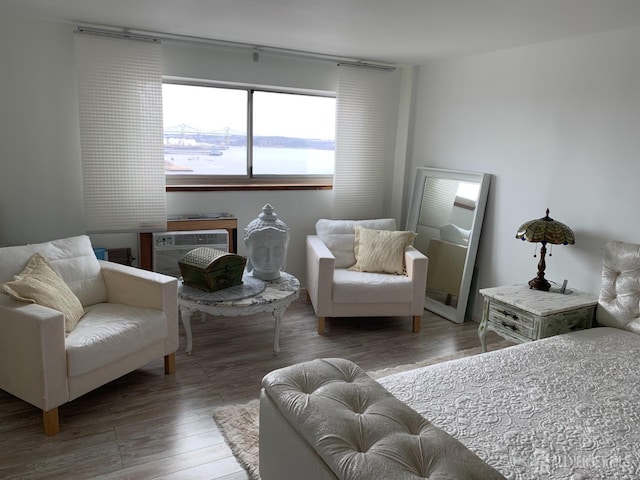 living area with a wall unit AC and wood finished floors