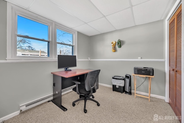 carpeted office space featuring a baseboard heating unit, a drop ceiling, and baseboards