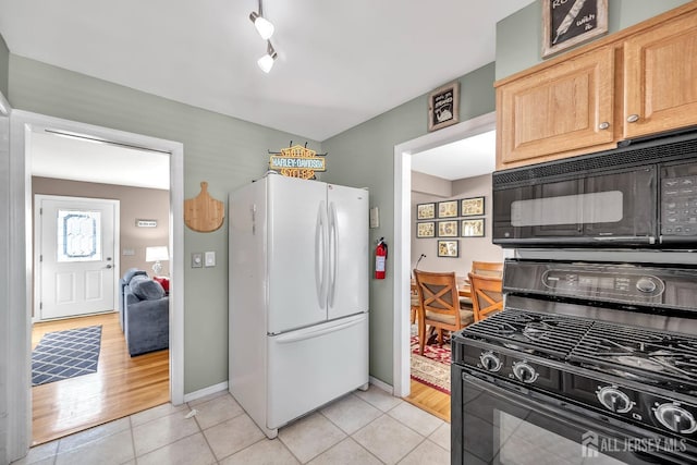 kitchen featuring black appliances, light tile patterned floors, and baseboards