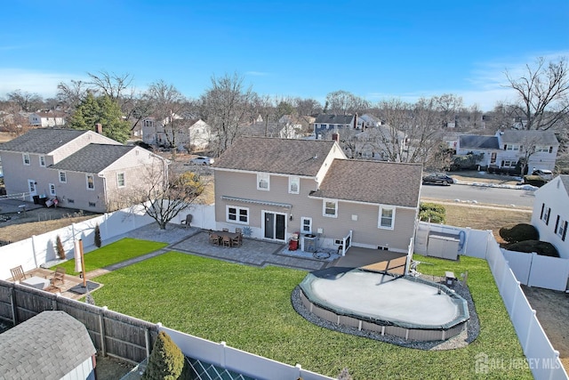 rear view of property with a lawn, a patio area, a fenced backyard, and a residential view