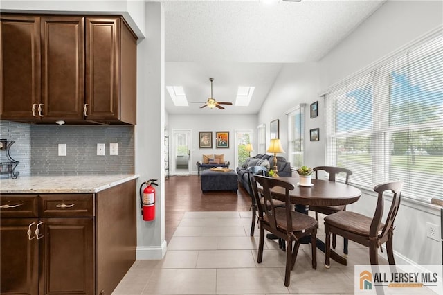 24 Birmingham Ln, Monroe, NJ 08831 - dining room featuring a skylight, lofted ceiling, light tile patterned flooring, a textured ceiling, and a ceiling fan
