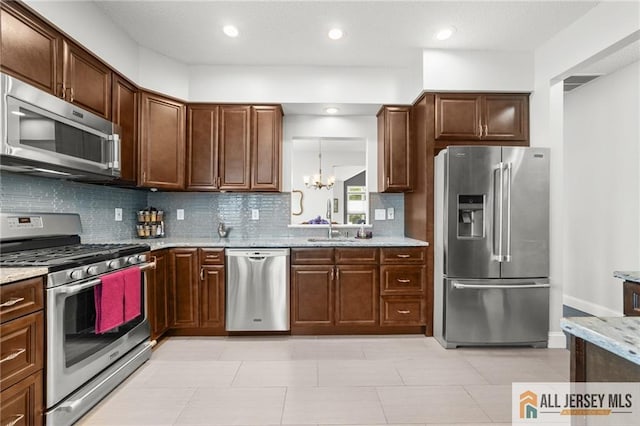 24 Birmingham Ln, Monroe, NJ 08831 - kitchen with stainless steel appliances, tasteful backsplash, a chandelier, light stone countertops, and light tile patterned floors