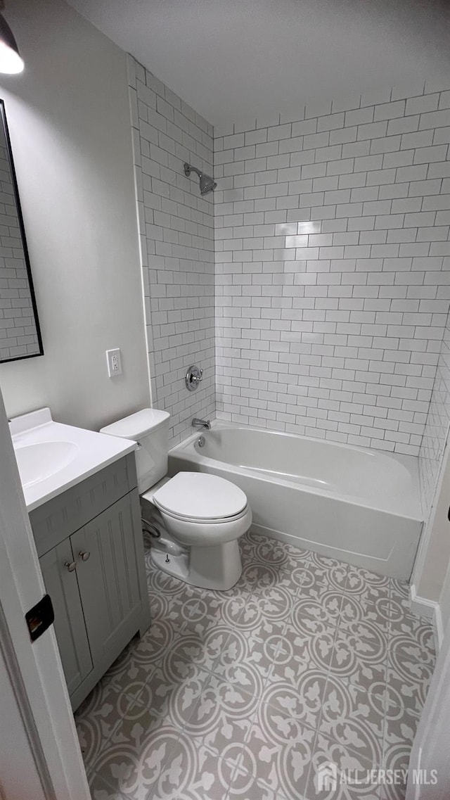 full bathroom with tile patterned flooring, vanity, toilet, and tiled shower / bath