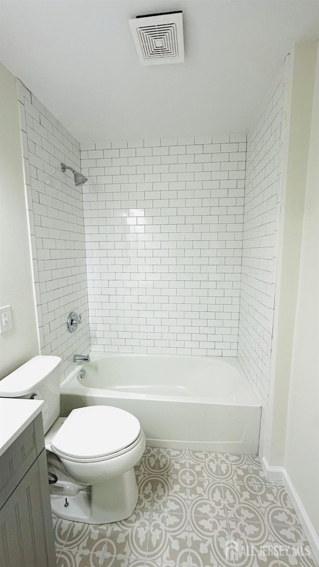 full bathroom with tiled shower / bath combo, vanity, tile patterned flooring, and toilet