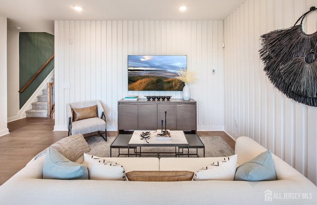 living area featuring recessed lighting, baseboards, wood finished floors, and stairway