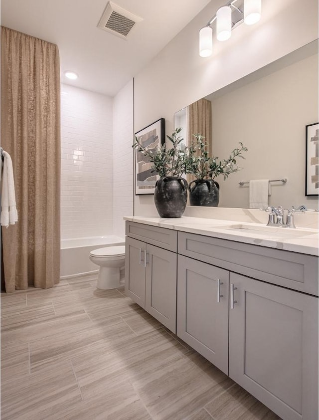 full bathroom with shower / bath combo, vanity, toilet, wood finished floors, and visible vents