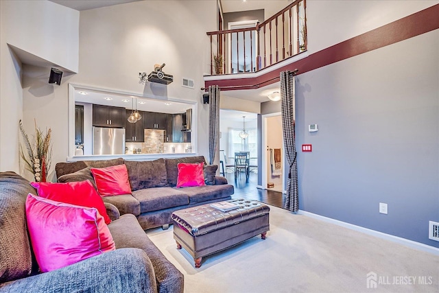 55 Renaissance Ln, New Brunswick, NJ 08901 - living room featuring a towering ceiling, baseboards, and carpet floors