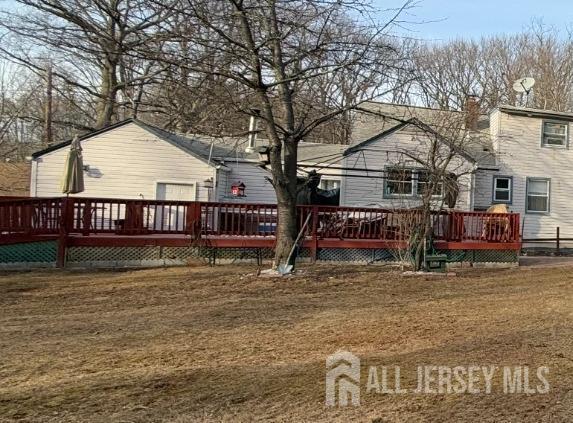 back of house with a yard and a wooden deck