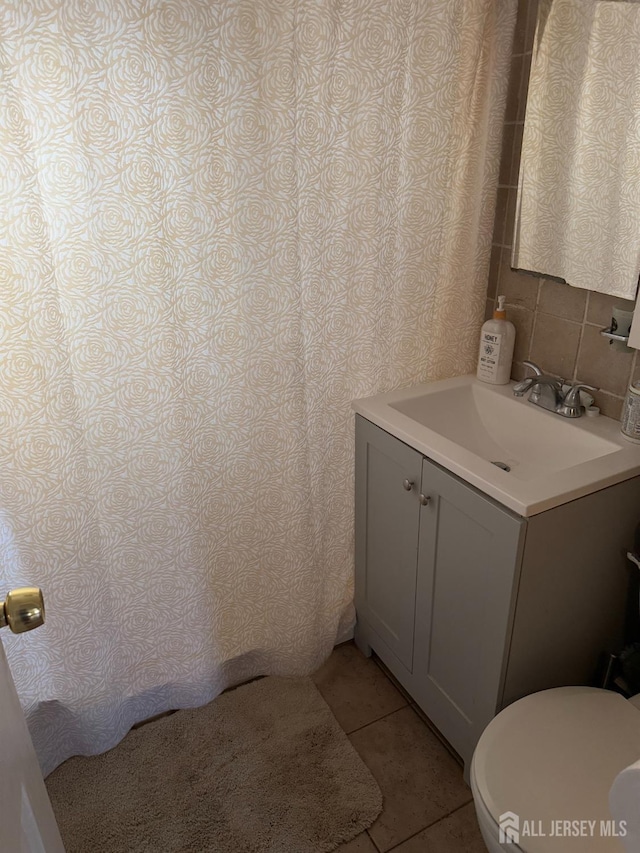 full bath with tile patterned flooring, vanity, and toilet