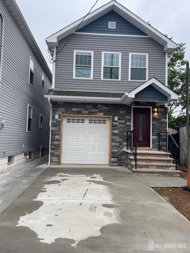 424 Steadman Pl, Perth Amboy, NJ 08861 - view of front facade featuring stone siding, a garage, and driveway