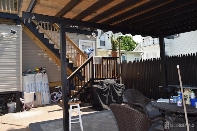 view of patio with stairs, fence, and area for grilling