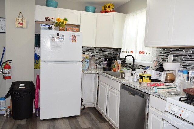 kitchen featuring light stone counters, sink, white appliances, and white cabinets