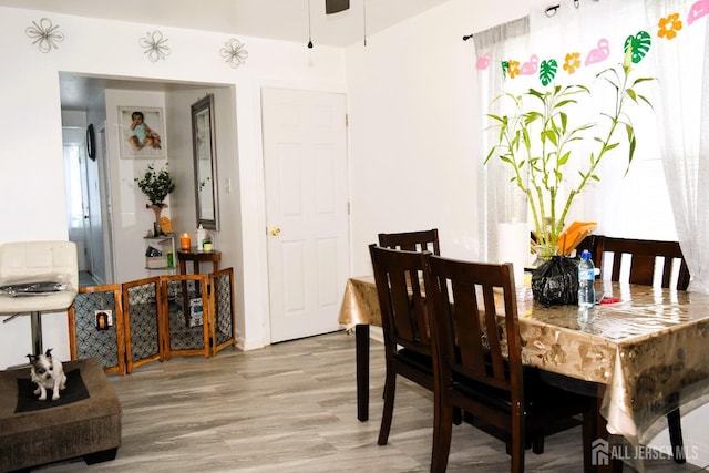 dining space with a ceiling fan and wood finished floors