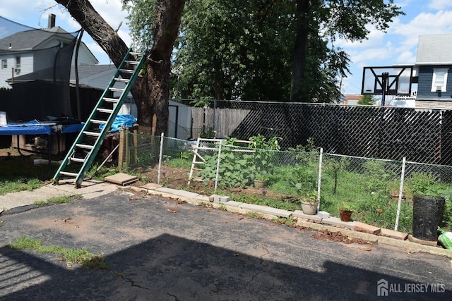 view of yard with a fenced backyard and a trampoline