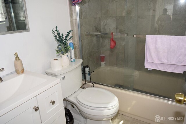 full bathroom with bath / shower combo with glass door, vanity, and toilet