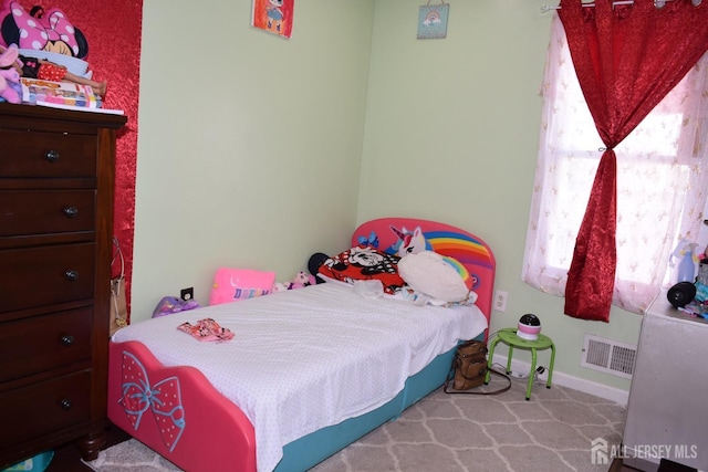 bedroom featuring visible vents, light carpet, and baseboards